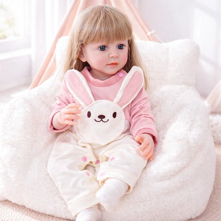 Chimidoll - muñeca renacida de niña pequeña, vestida con un conjunto de mono de conejito rosa.