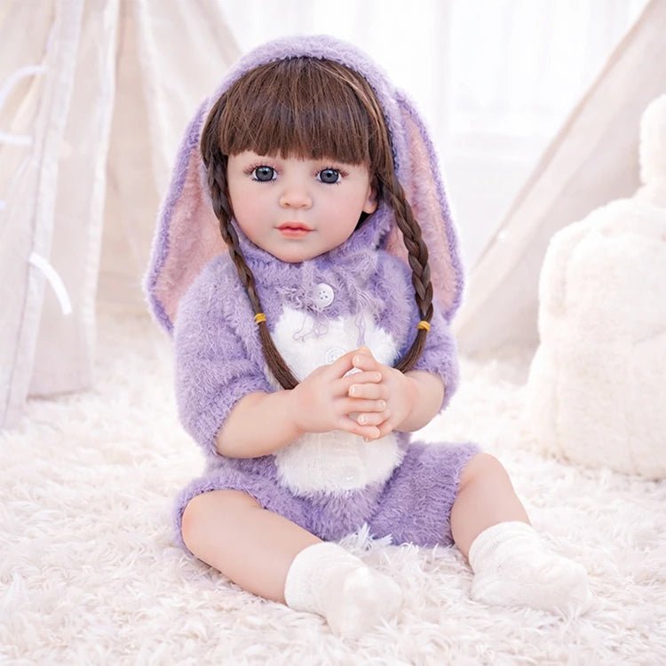 Chimidoll - muñeca realista de niño pequeño con un atuendo de conejito morado y cabello largo negro.