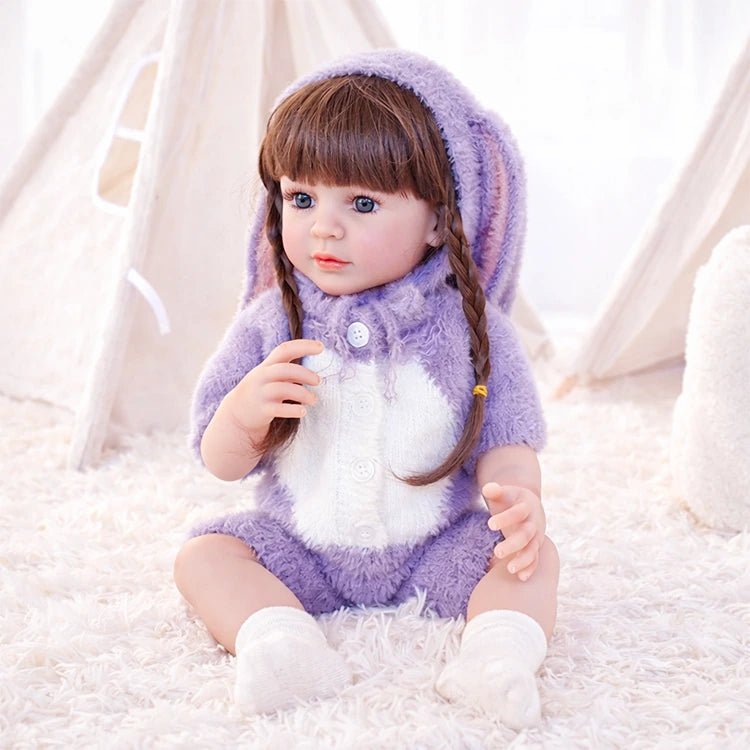Chimidoll - muñeca realista de niño pequeño con un atuendo de conejito morado y cabello largo negro.