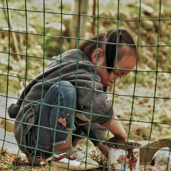 A poor little girl playing in the mud