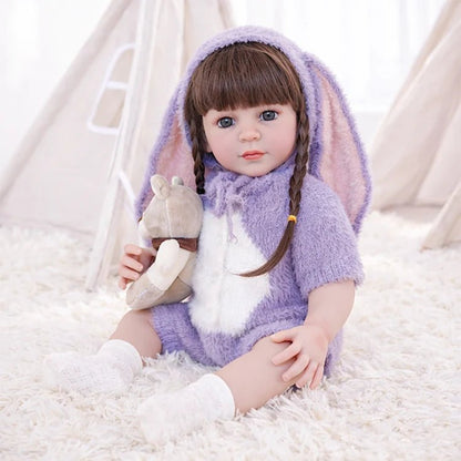Chimidoll - muñeca realista de niño pequeño con un atuendo de conejito morado y cabello largo negro.