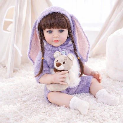 Chimidoll - muñeca realista de niño pequeño con un atuendo de conejito morado y cabello largo negro.