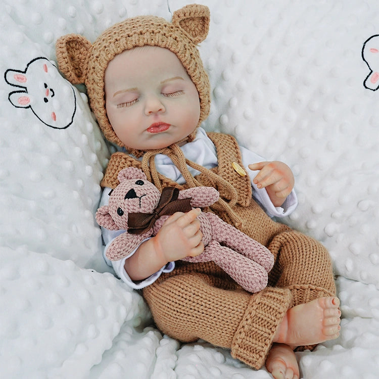 Complete brown knit reborn doll clothes set with white cotton long-sleeve bodysuit, textured suspenders featuring two decorative wood buttons, and matching ribbed bonnet for 20-inch dolls