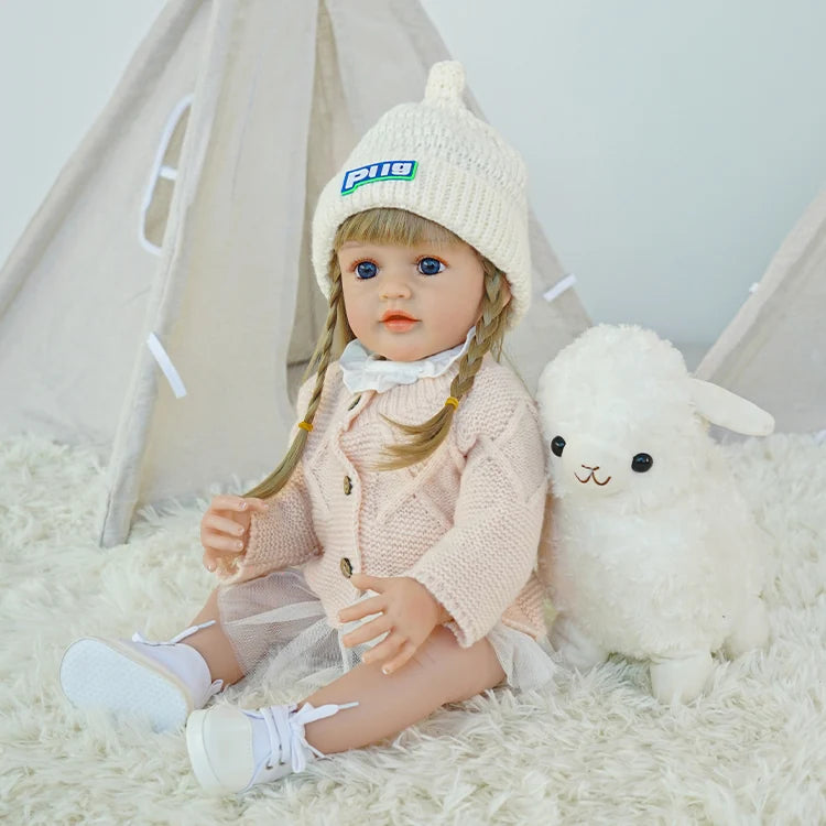 Side view of reborn doll sitting on the carpet, hands on legs.